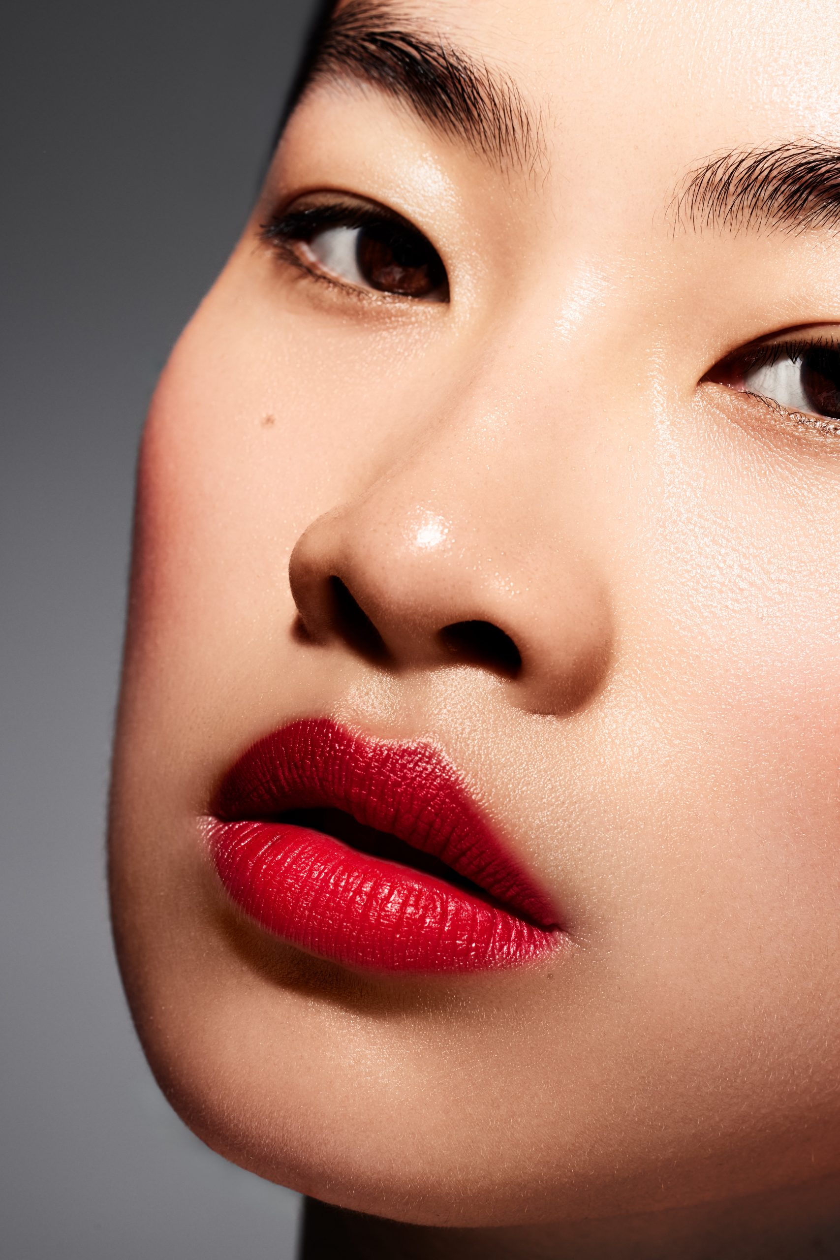 Extreme beauty close-up, red lipstick and glowing skin texture, editorial beauty photography by Furkan Ramadani